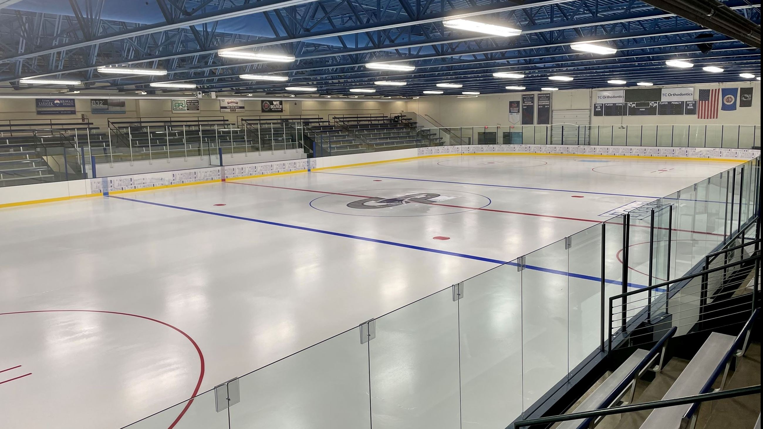 A view of the ice forum logo with center ice and the stands in view.